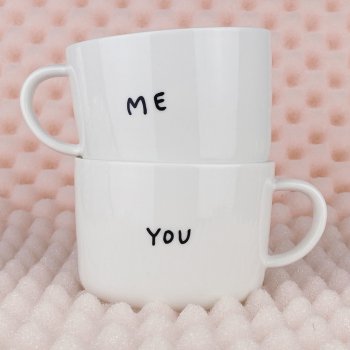 Zwei gestapelte Tassen mit Aufdruck „Me“ und „You“